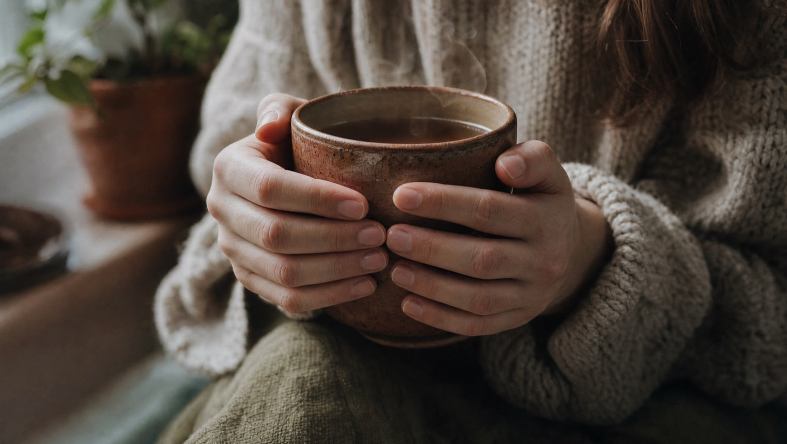 Hands wrapped tightly together for warmth, cool tones