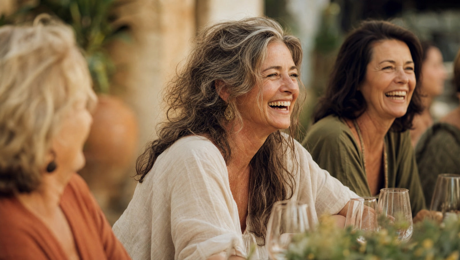 A woman laughing with friends at a warm gathering, vibrant and present