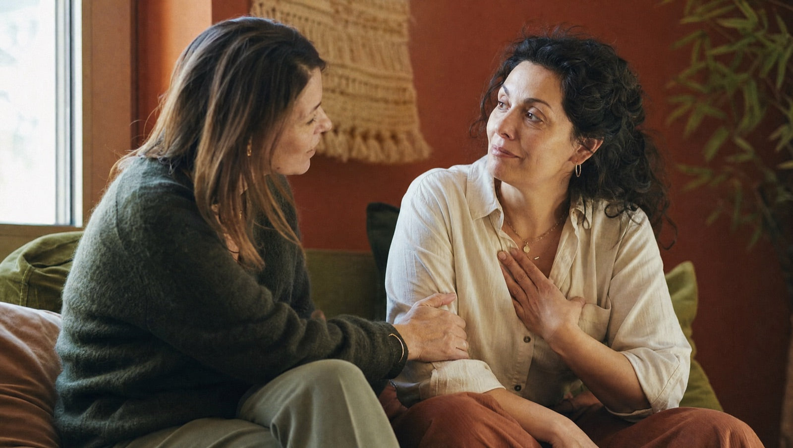 Two women on a sofa, one reassuring and validating the other